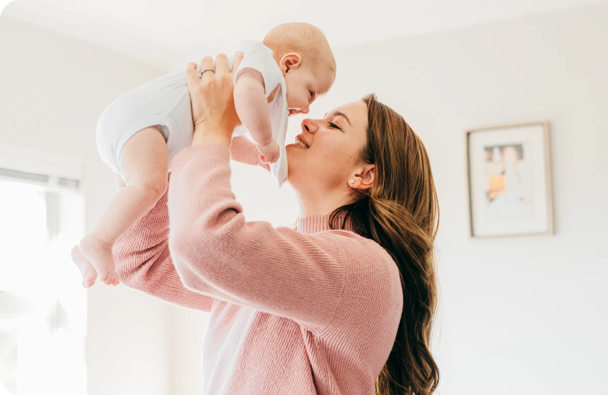 Woman holding baby in sunlight
